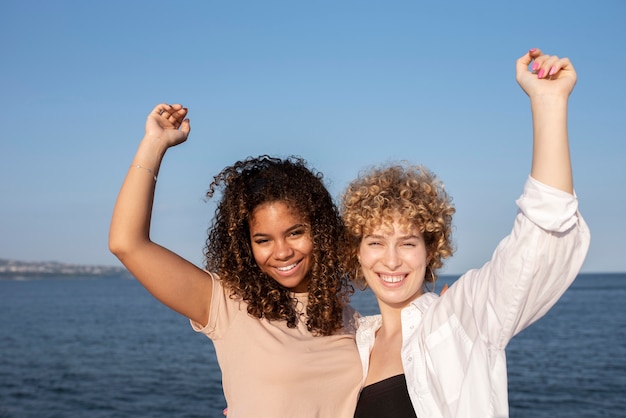 Foto gratuita amici sorridenti a tiro medio in riva al mare