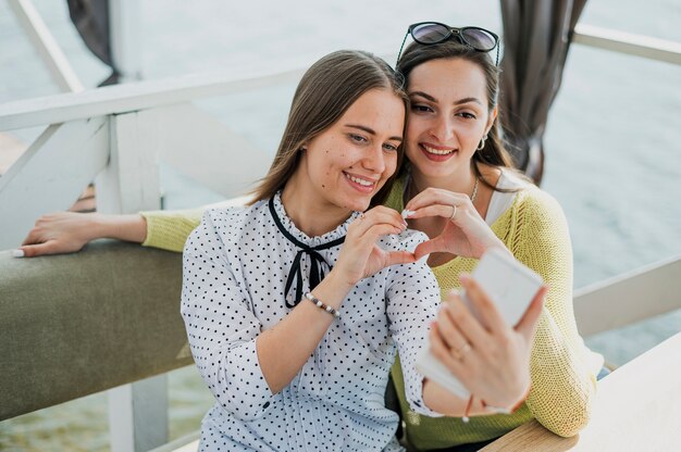 Medium shot smiley friends taking a selfie