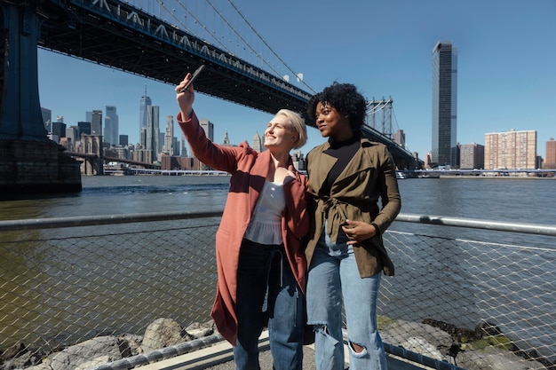 Medium shot smiley friends taking selfie