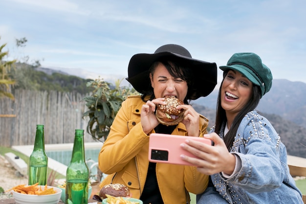 Medium shot smiley friends taking selfie