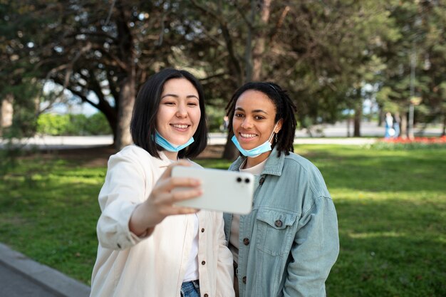 Medium shot smiley friends taking selfie