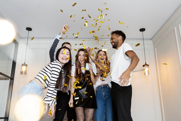 Free photo medium shot smiley friends with confetti