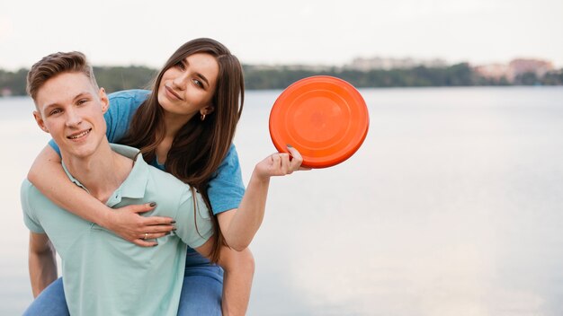 Medium shot smiley friends with frisbee outdoors