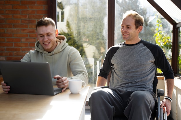 Free photo medium shot smiley friends with laptop