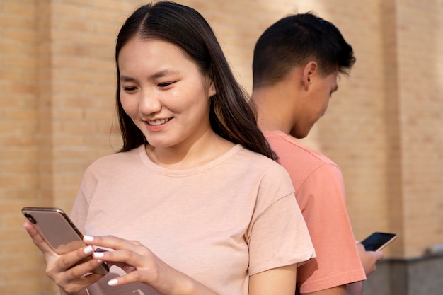 Foto gratuita amici sorridenti di tiro medio con i telefoni