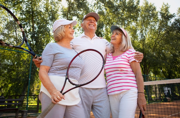 Free photo medium shot smiley friends with racket