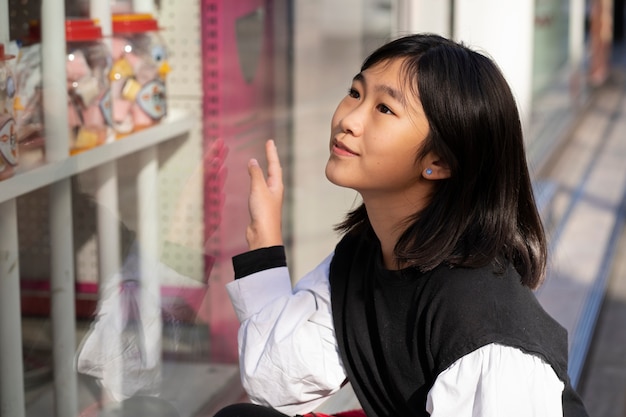 무료 사진 가게에서 중간 샷 웃는 소녀