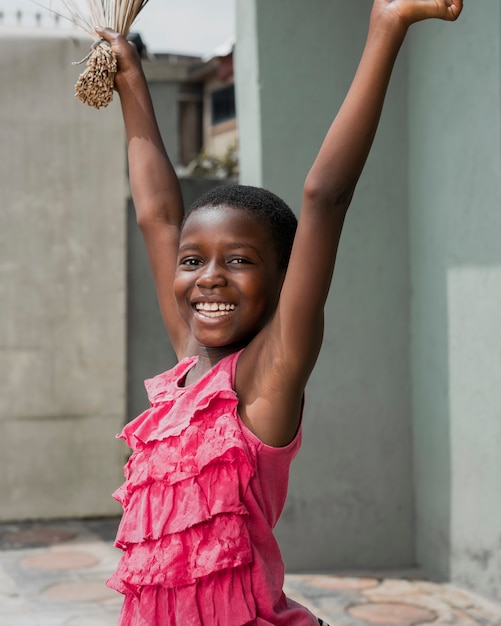 Medium shot smiley girl holding broom