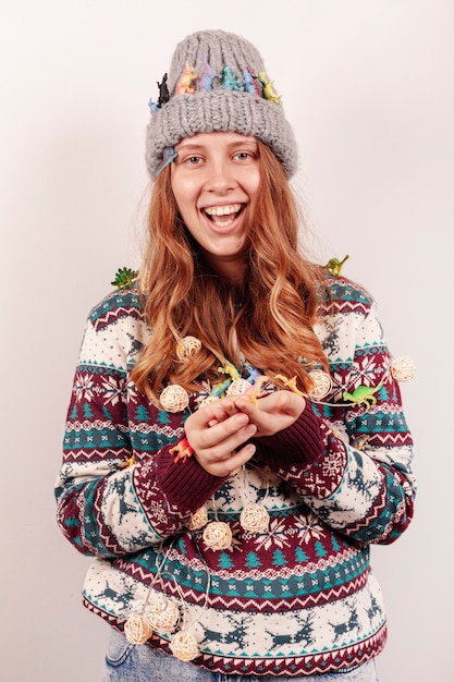 Free photo medium shot smiley girl holding christmas lights