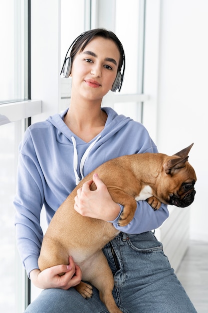 Free photo medium shot smiley girl holding dog