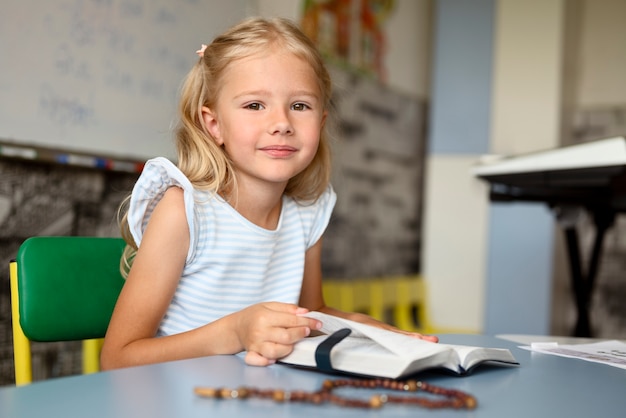 Foto gratuita ragazza sorridente del colpo medio alla scuola della domenica