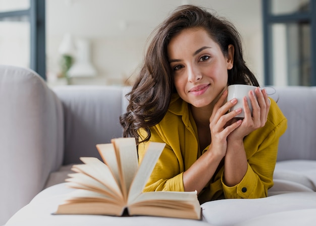 Free photo medium shot smiley girl with book and cup