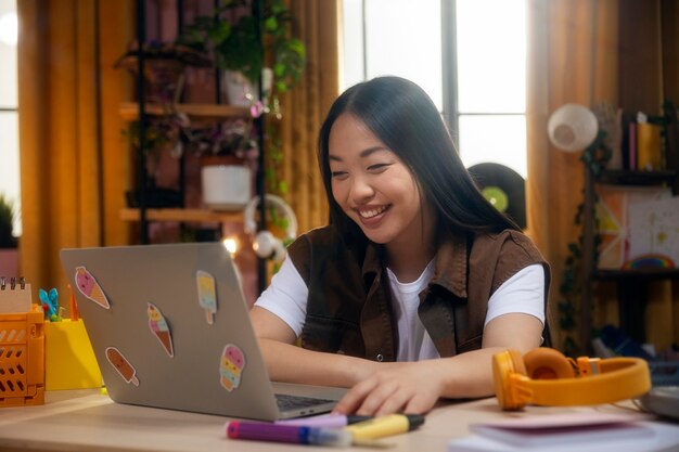 노트북과 중간 샷 웃는 소녀