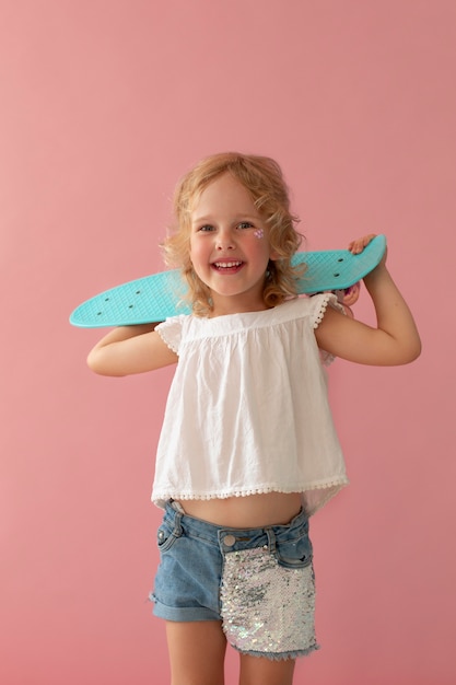 Foto gratuita ragazza sorridente di colpo medio con pennyboard
