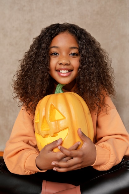 Medium shot smiley girl with pumpkin