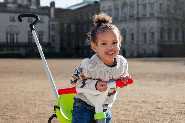 Free photo medium shot smiley girl with tricycle