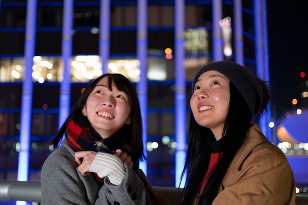 Free photo medium shot smiley girls hanging out in city