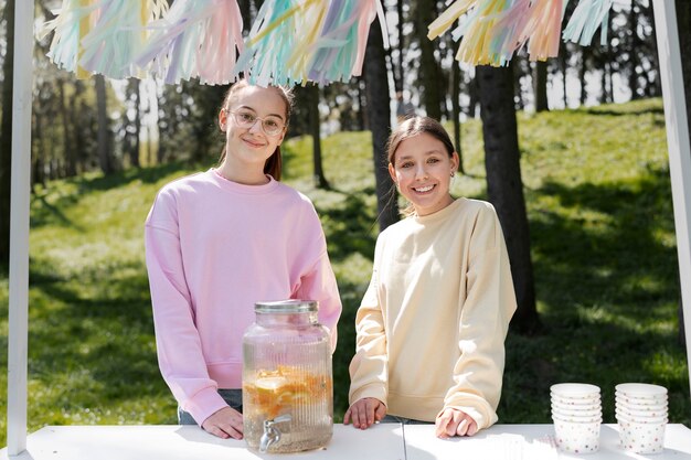 Medium shot smiley girls with lemonade