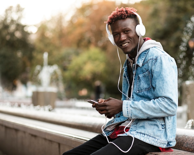 Medium shot smiley guy listening to music