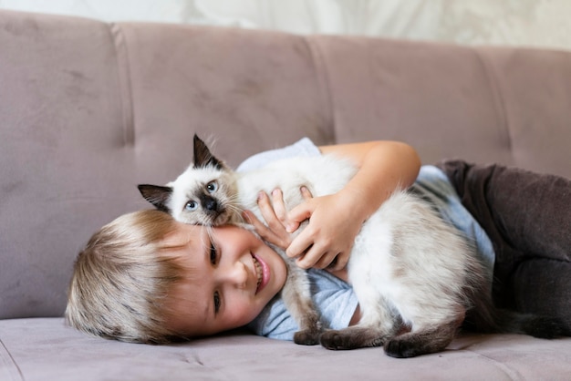 かわいい猫を抱いたミディアムショットのスマイリーキッド