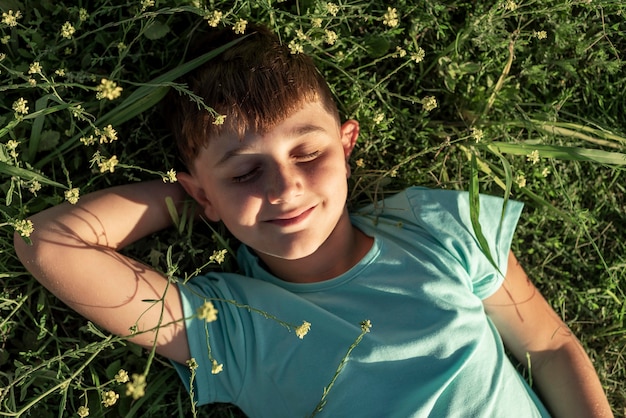 Free photo medium shot smiley kid laying on grass