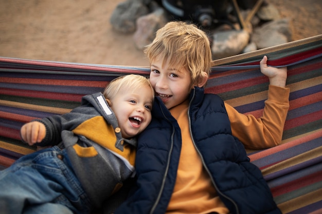 Free photo medium shot smiley kids on hammock