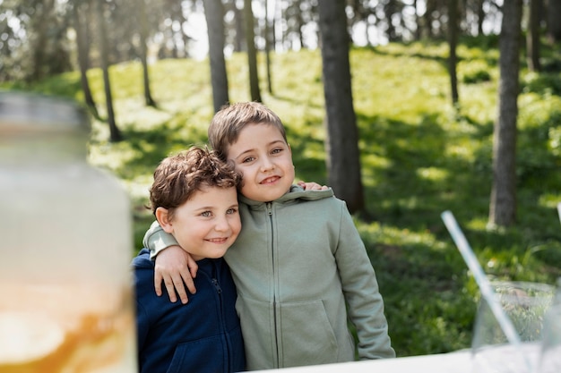 Free photo medium shot smiley kids hugging outdoors