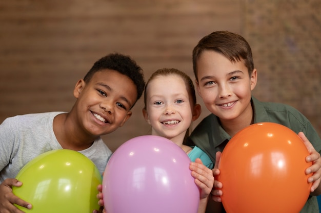 Medium shot smiley kids with balloons