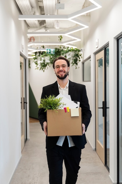 Free photo medium shot smiley man carrying box