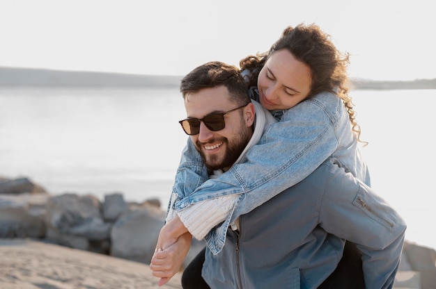 Medium shot smiley man carrying girlfriend