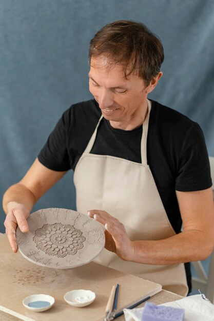 Medium shot smiley man doing pottery