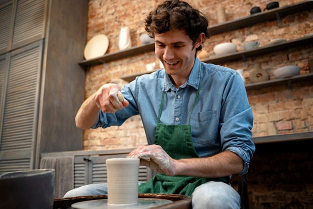 Medium shot smiley man doing pottery