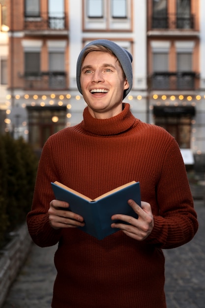 Medium shot smiley man holding book