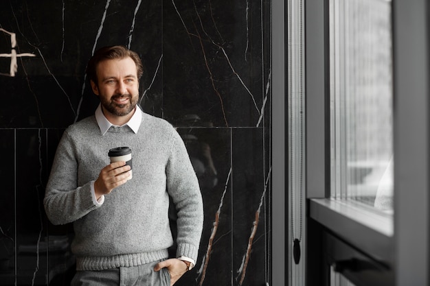 Free photo medium shot smiley man holding coffee cup