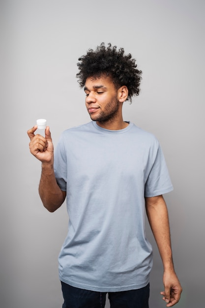 Free photo medium shot smiley man holding cream container