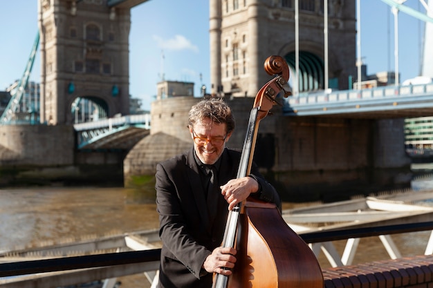 Medium shot smiley man holding double bass