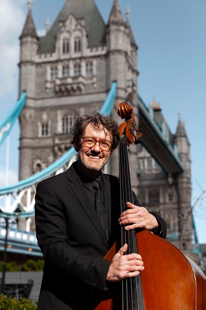 Free photo medium shot smiley man holding double bass