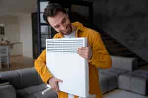 Free photo medium shot smiley man holding heater