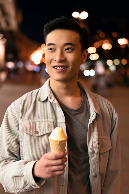 Free photo medium shot smiley man holding ice cream