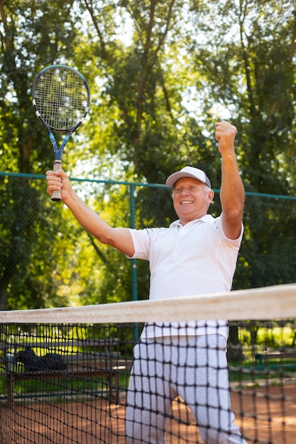 Medium shot smiley man holding racket