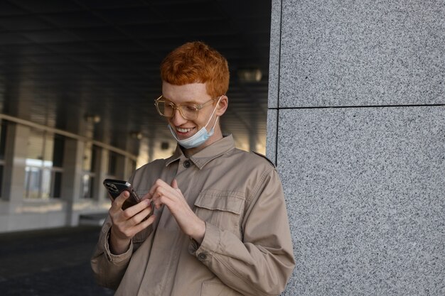 Medium shot smiley man holding smartphone