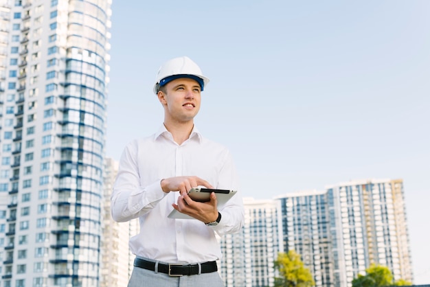 Free photo medium shot smiley man holding a tablet