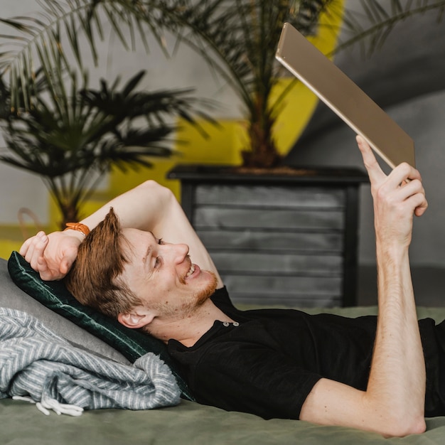 Medium shot smiley man holding tablet