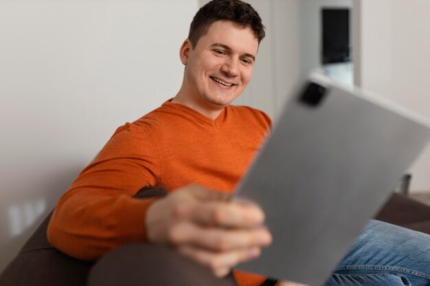 Medium shot smiley man holding tablet