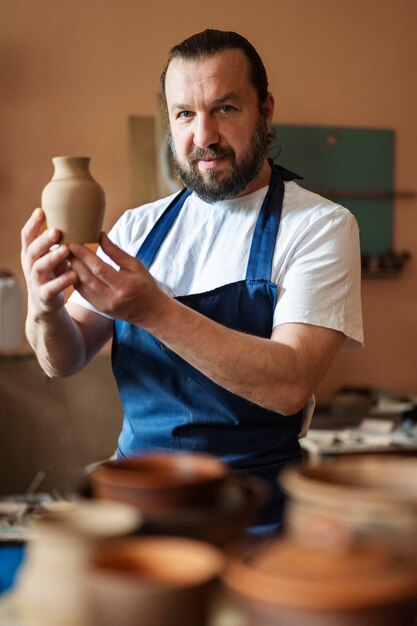 Medium shot smiley man holding vase