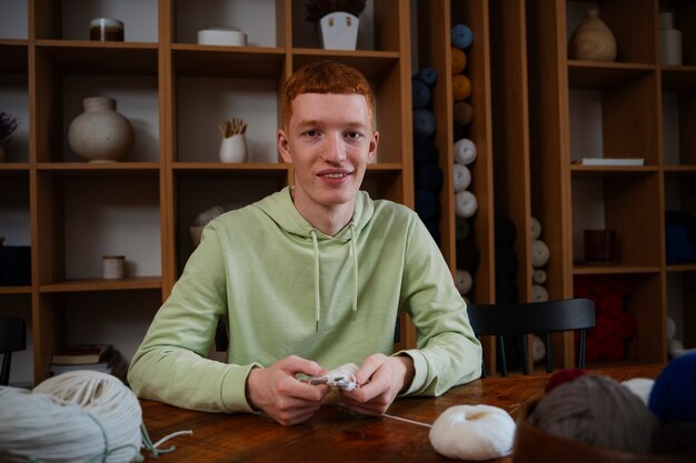 Medium shot smiley man knitting