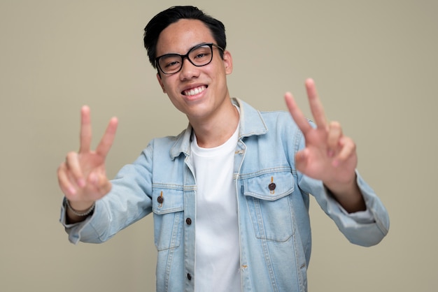 Medium shot smiley man making peace sign