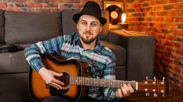 Medium shot smiley man playing the guitar