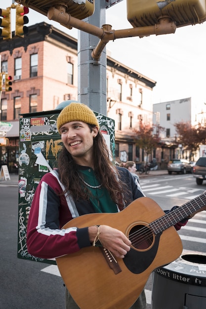 Medium shot smiley man playing the guitar