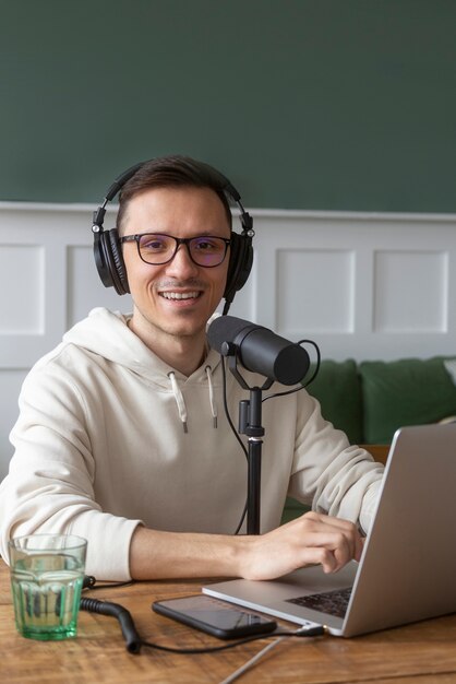 medium shot smiley man recording podcast